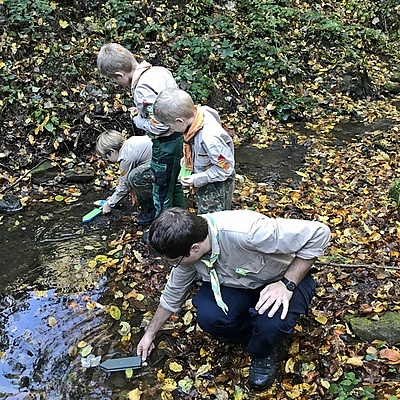 Kinder lassen Boote auf Bocksbach fahren