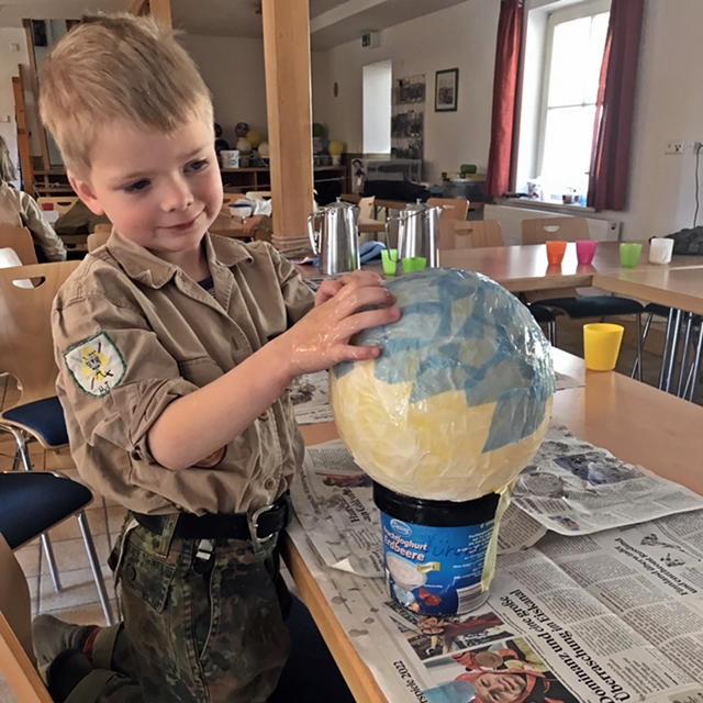 Junger Pfadfinder klebt Transparentpapier auf Ballon